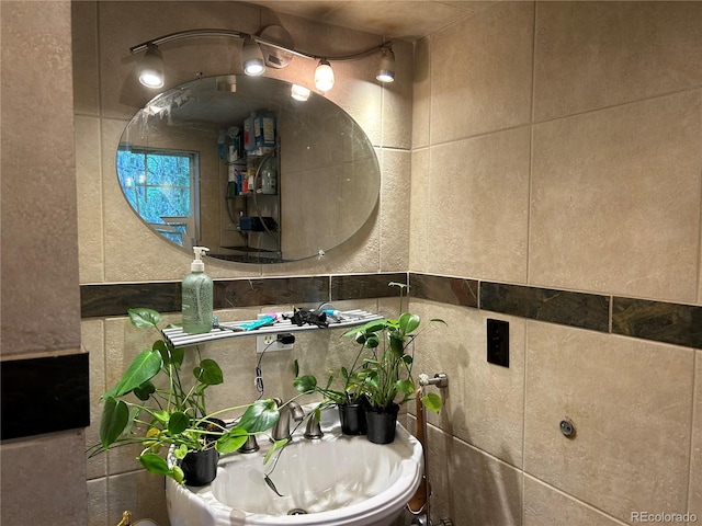 bathroom featuring sink and tile walls