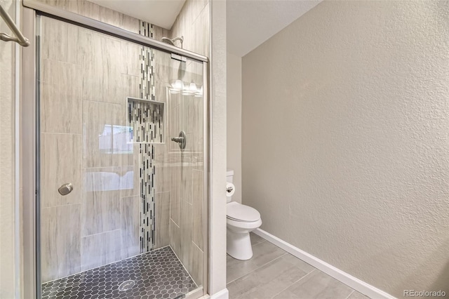 12668 W 1st Pl Unit 81, Denver, CO 80228 - full bathroom featuring toilet, a stall shower, a textured wall, baseboards, and wood finished floors