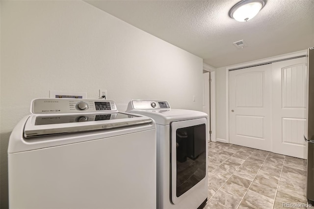12668 W 1st Pl Unit 81, Denver, CO 80228 - laundry area with washing machine and clothes dryer and a textured ceiling