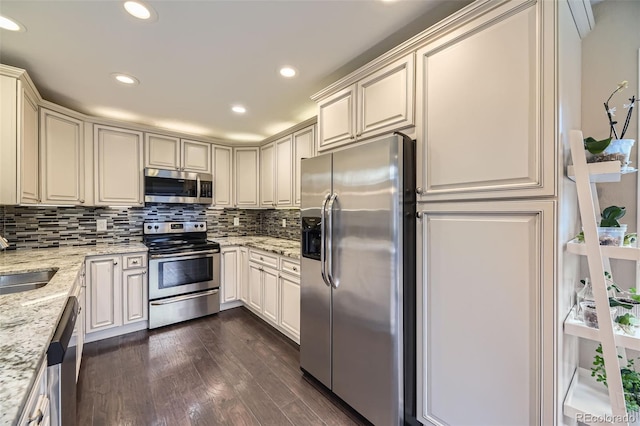 12668 W 1st Pl Unit 81, Denver, CO 80228 - kitchen featuring stainless steel appliances, dark wood-type flooring, light stone countertops, tasteful backsplash, and recessed lighting