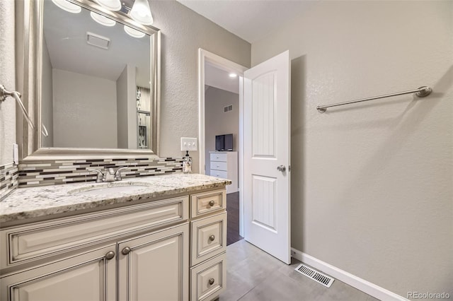 12668 W 1st Pl Unit 81, Denver, CO 80228 - bathroom with vanity, decorative backsplash, tile patterned floors, and baseboards