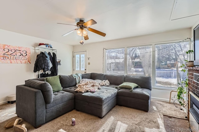 living room with carpet, ceiling fan, and a brick fireplace