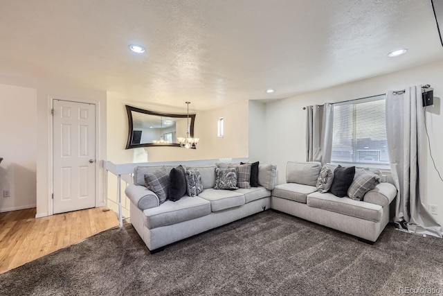 living room with wood-type flooring, a textured ceiling, and a notable chandelier