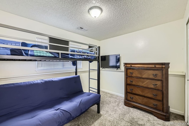 bedroom with a textured ceiling and light carpet