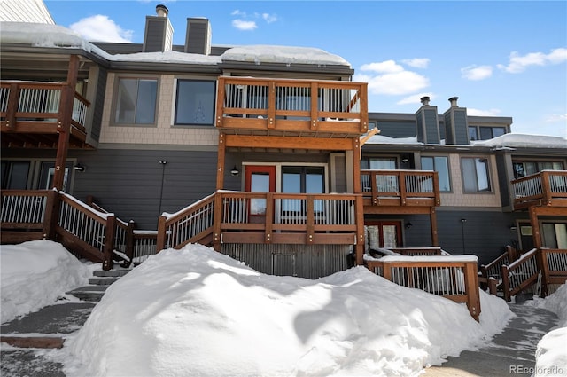 snow covered house featuring a balcony