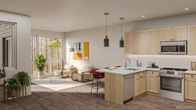 kitchen with stainless steel appliances, light countertops, a sink, and light brown cabinetry