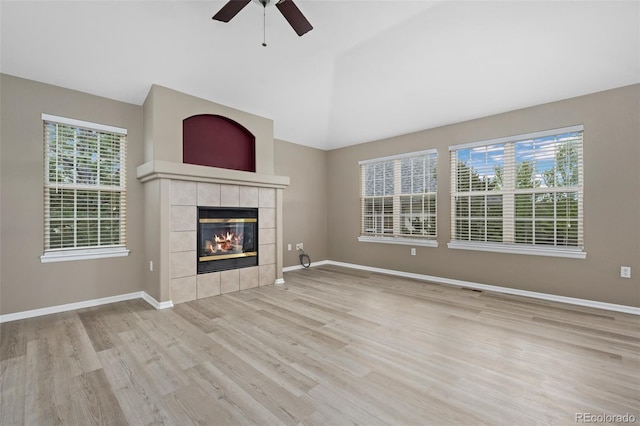 8258 S Sicily Ct, Aurora, CO 80016 - unfurnished living room with wood finished floors, a ceiling fan, a fireplace, vaulted ceiling, and baseboards