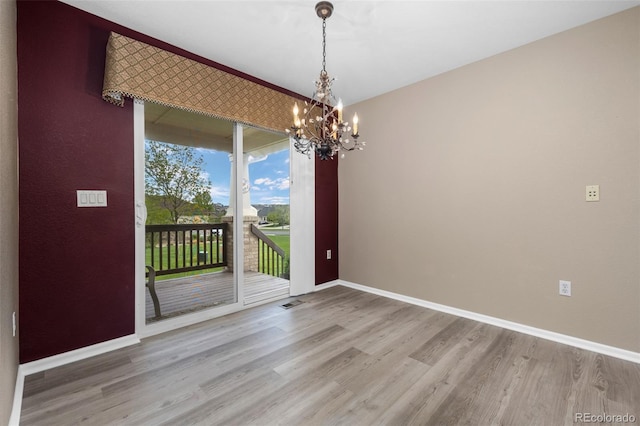 8258 S Sicily Ct, Aurora, CO 80016 - spare room featuring a chandelier, wood finished floors, and baseboards