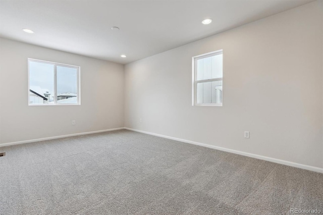 empty room with carpet flooring, recessed lighting, baseboards, and a wealth of natural light