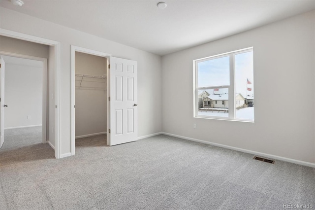 unfurnished bedroom with visible vents, carpet floors, and baseboards