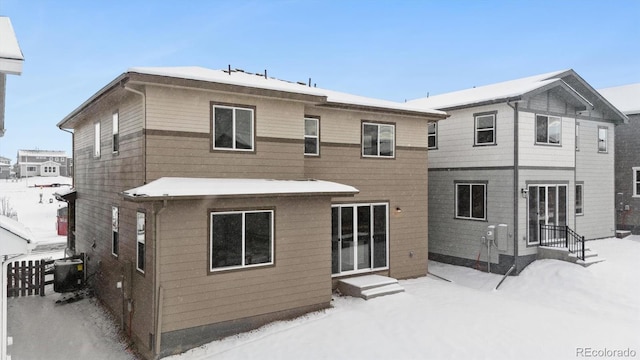 snow covered rear of property with central air condition unit