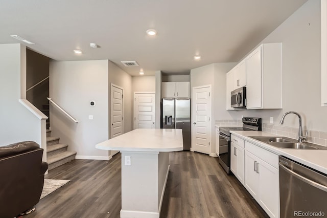 630 Apache Trl Unit D2, Ault, CO 80610 - kitchen featuring appliances with stainless steel finishes, a kitchen island, white cabinetry, dark wood-style flooring, and recessed lighting