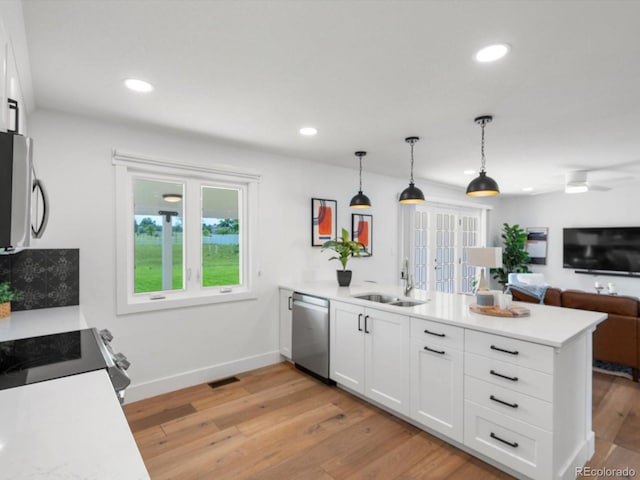 15229 Navajo St, Broomfield, CO 80023 - kitchen with appliances with stainless steel finishes, a peninsula, white cabinetry, plenty of natural light, and recessed lighting