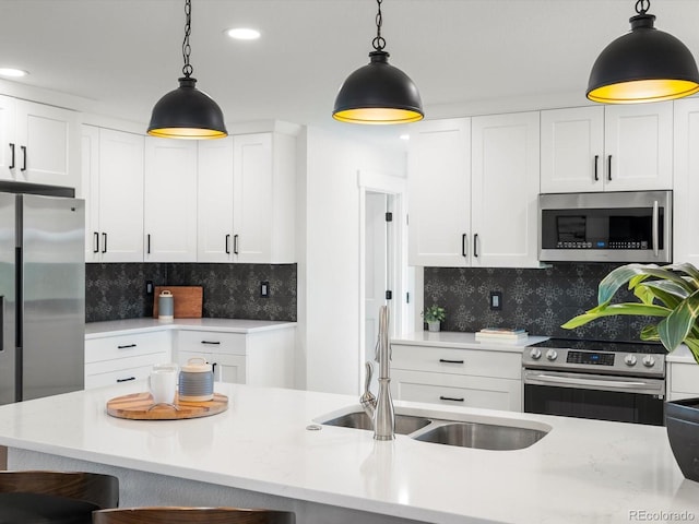 15229 Navajo St, Broomfield, CO 80023 - kitchen featuring appliances with stainless steel finishes, white cabinetry, decorative backsplash, pendant lighting, and recessed lighting