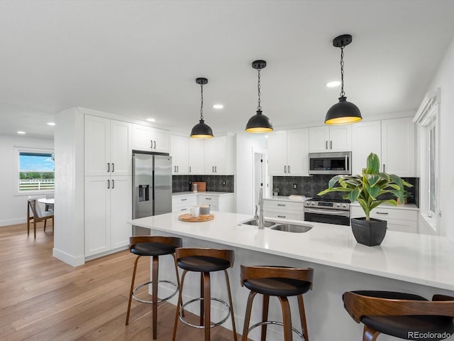 15229 Navajo St, Broomfield, CO 80023 - kitchen with stainless steel appliances, a kitchen bar, recessed lighting, backsplash, and white cabinets