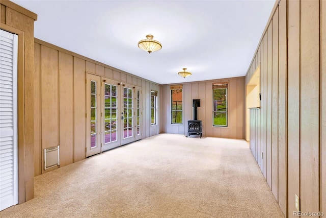 29090 Golf Way, Evergreen, CO 80439 - unfurnished living room featuring a wood stove, carpet flooring, french doors, and wood walls