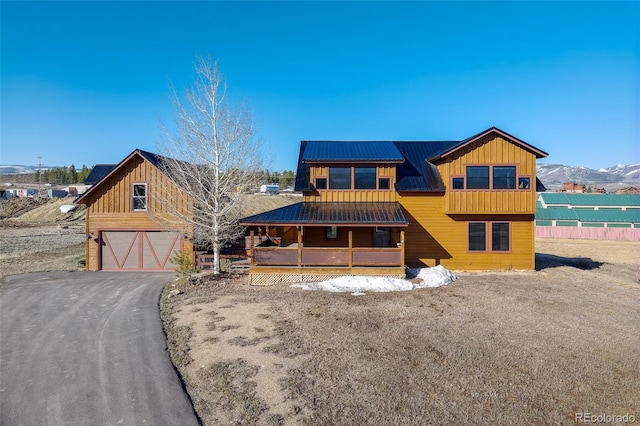 127 Silver Sage Rd, Granby, CO 80446 - view of front of house featuring board and batten siding, an attached garage, covered porch, and aphalt driveway