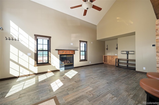 127 Silver Sage Rd, Granby, CO 80446 - unfurnished living room featuring baseboards, a glass covered fireplace, high vaulted ceiling, ceiling fan, and wood finish floors