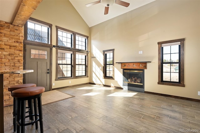 127 Silver Sage Rd, Granby, CO 80446 - interior space featuring high vaulted ceiling, a ceiling fan, wood finished floors, a glass covered fireplace, and baseboards