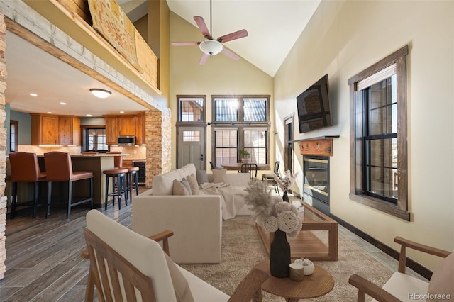 127 Silver Sage Rd, Granby, CO 80446 - living room featuring dark wood finished floors, a glass covered fireplace, recessed lighting, a ceiling fan, and high vaulted ceiling