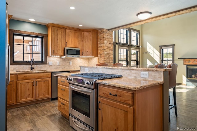 127 Silver Sage Rd, Granby, CO 80446 - kitchen featuring a kitchen breakfast bar, tasteful backsplash, a sink, stainless steel appliances, and dark wood-style floors
