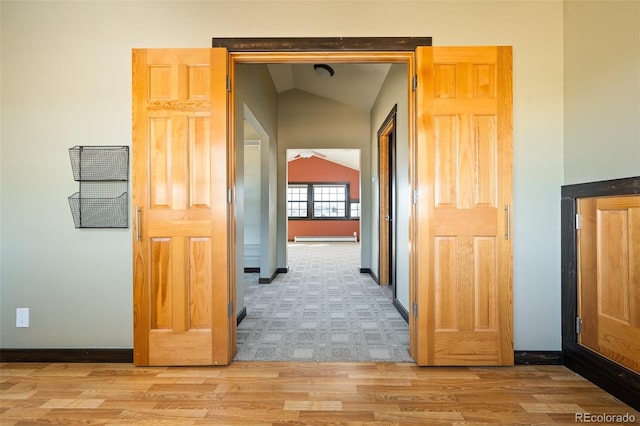 127 Silver Sage Rd, Granby, CO 80446 - hall with vaulted ceiling, a baseboard heating unit, light carpet, light wood finished floors, and baseboards