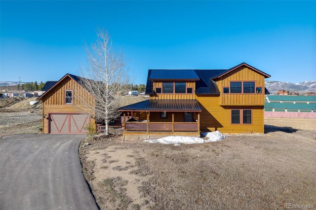 127 Silver Sage Rd, Granby, CO 80446 - view of front of house featuring board and batten siding, an attached garage, covered porch, and aphalt driveway