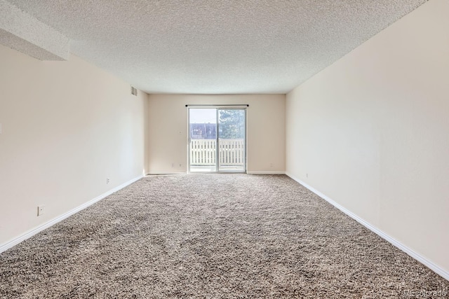 carpeted empty room with a textured ceiling