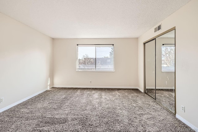 unfurnished bedroom featuring a closet, carpet floors, and a textured ceiling