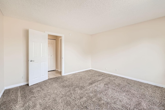 empty room with light carpet and a textured ceiling