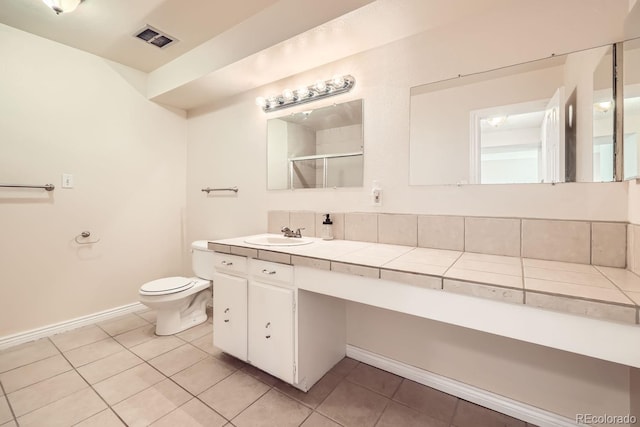 bathroom with tile patterned flooring, vanity, toilet, and a shower with door