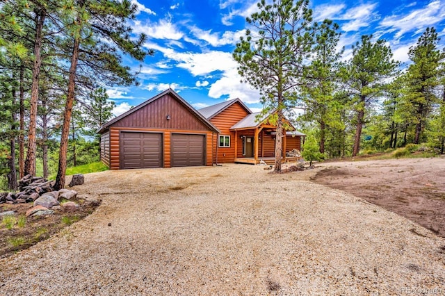 4513 County Road 323, Westcliffe, CO 81252 - rustic home featuring dirt driveway, a porch, log veneer siding, an attached garage, and a metal roof