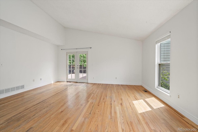 904 Clover Cir, Lafayette, CO 80026 - empty room featuring light wood finished floors, french doors, baseboards, and high vaulted ceiling