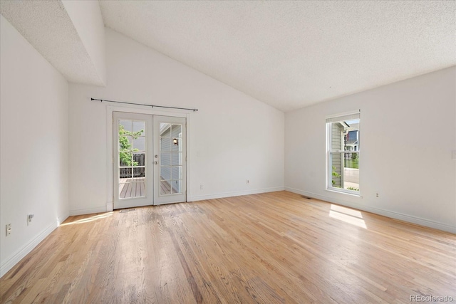 904 Clover Cir, Lafayette, CO 80026 - unfurnished room with light wood finished floors, french doors, baseboards, vaulted ceiling, and a textured ceiling