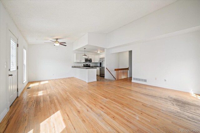 904 Clover Cir, Lafayette, CO 80026 - unfurnished living room with ceiling fan, light wood finished floors, and baseboards