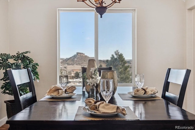 dining space featuring a mountain view, plenty of natural light, and a notable chandelier