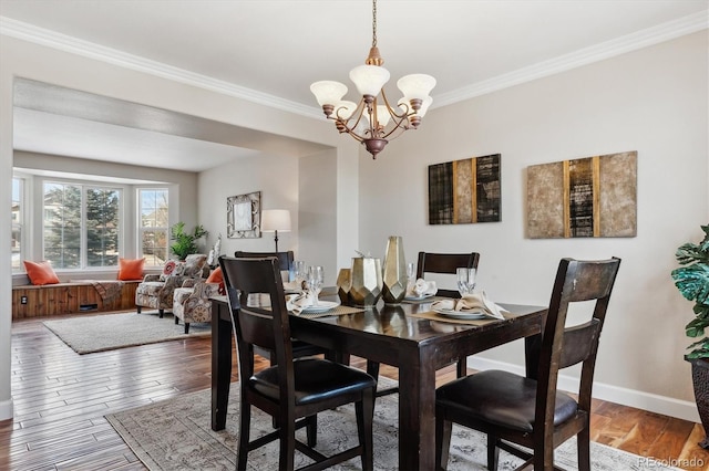 dining area featuring a chandelier, ornamental molding, and hardwood / wood-style flooring