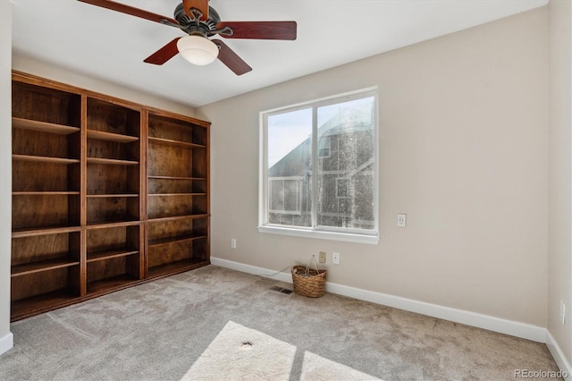 carpeted empty room featuring ceiling fan