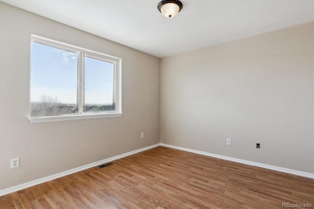 spare room with hardwood / wood-style flooring