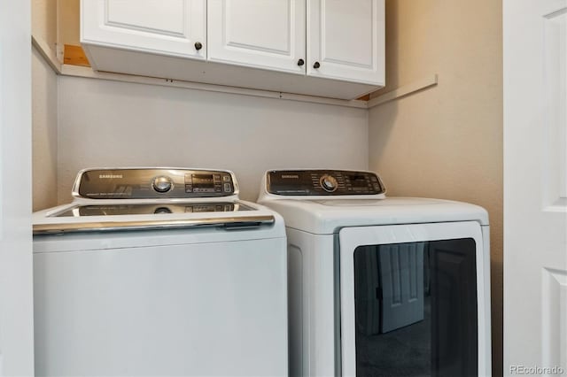 laundry room with cabinets and washer and clothes dryer