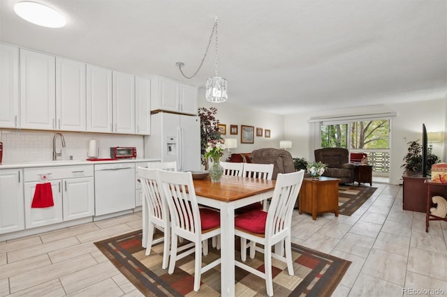 dining room with sink and a notable chandelier