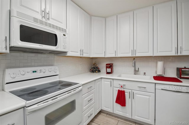 kitchen featuring sink, white cabinetry, decorative backsplash, and white appliances