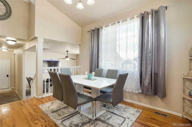 dining space featuring wood-type flooring, vaulted ceiling, ceiling fan, and plenty of natural light