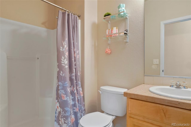 bathroom featuring curtained shower, vanity, and toilet