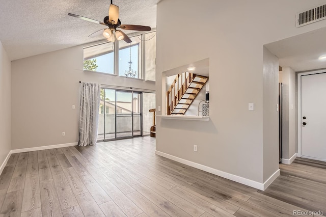 3539 S Fairplay Way Unit 10, Aurora, CO 80014 - unfurnished living room with baseboards, stairs, wood finished floors, high vaulted ceiling, and ceiling fan