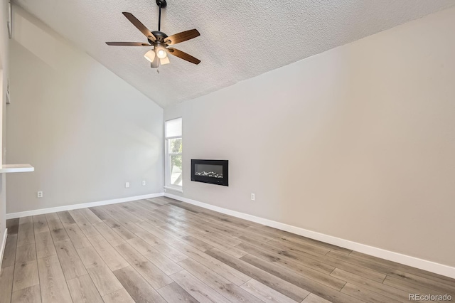 3539 S Fairplay Way Unit 10, Aurora, CO 80014 - unfurnished living room featuring a textured ceiling, ceiling fan, light wood-style floors, baseboards, and a glass covered fireplace