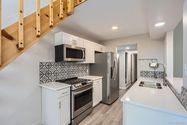 3539 S Fairplay Way Unit 10, Aurora, CO 80014 - kitchen with stainless steel appliances, a sink, light wood finished floors, tasteful backsplash, and light countertops