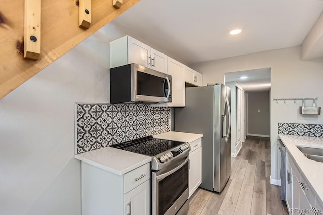 3539 S Fairplay Way Unit 10, Aurora, CO 80014 - kitchen with stainless steel appliances, light countertops, decorative backsplash, light wood-style flooring, and recessed lighting