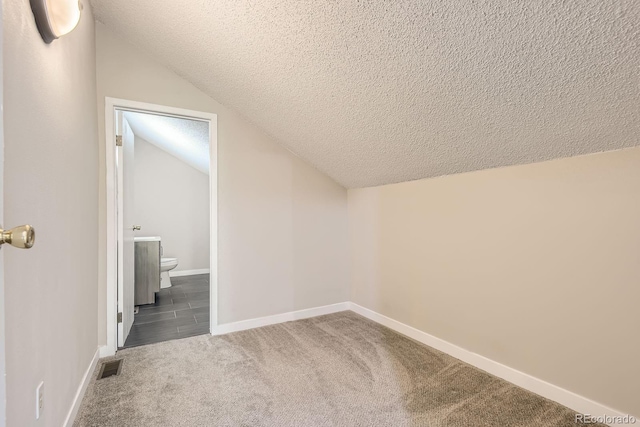 3539 S Fairplay Way Unit 10, Aurora, CO 80014 - additional living space with a textured ceiling, carpet floors, lofted ceiling, and baseboards