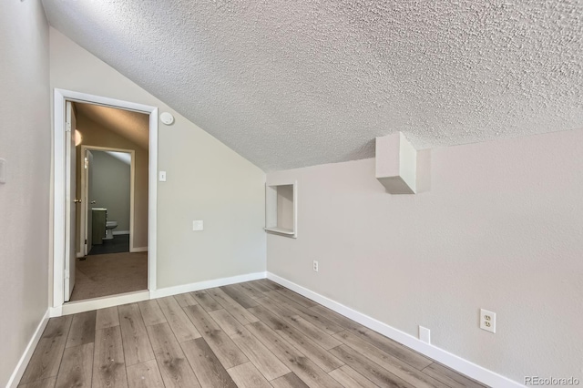 3539 S Fairplay Way Unit 10, Aurora, CO 80014 - additional living space featuring a textured ceiling, lofted ceiling, wood finished floors, and baseboards